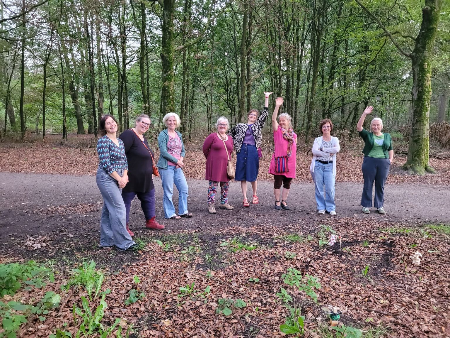 Een groep deelnemers poseert in het bos.